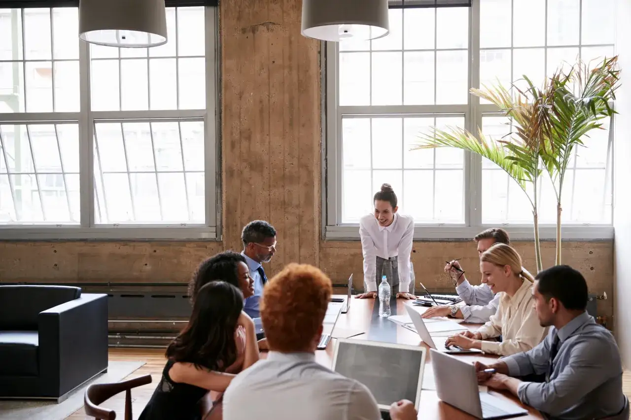 A diverse team collaborates, discussing nonprofit best practices around a conference table.